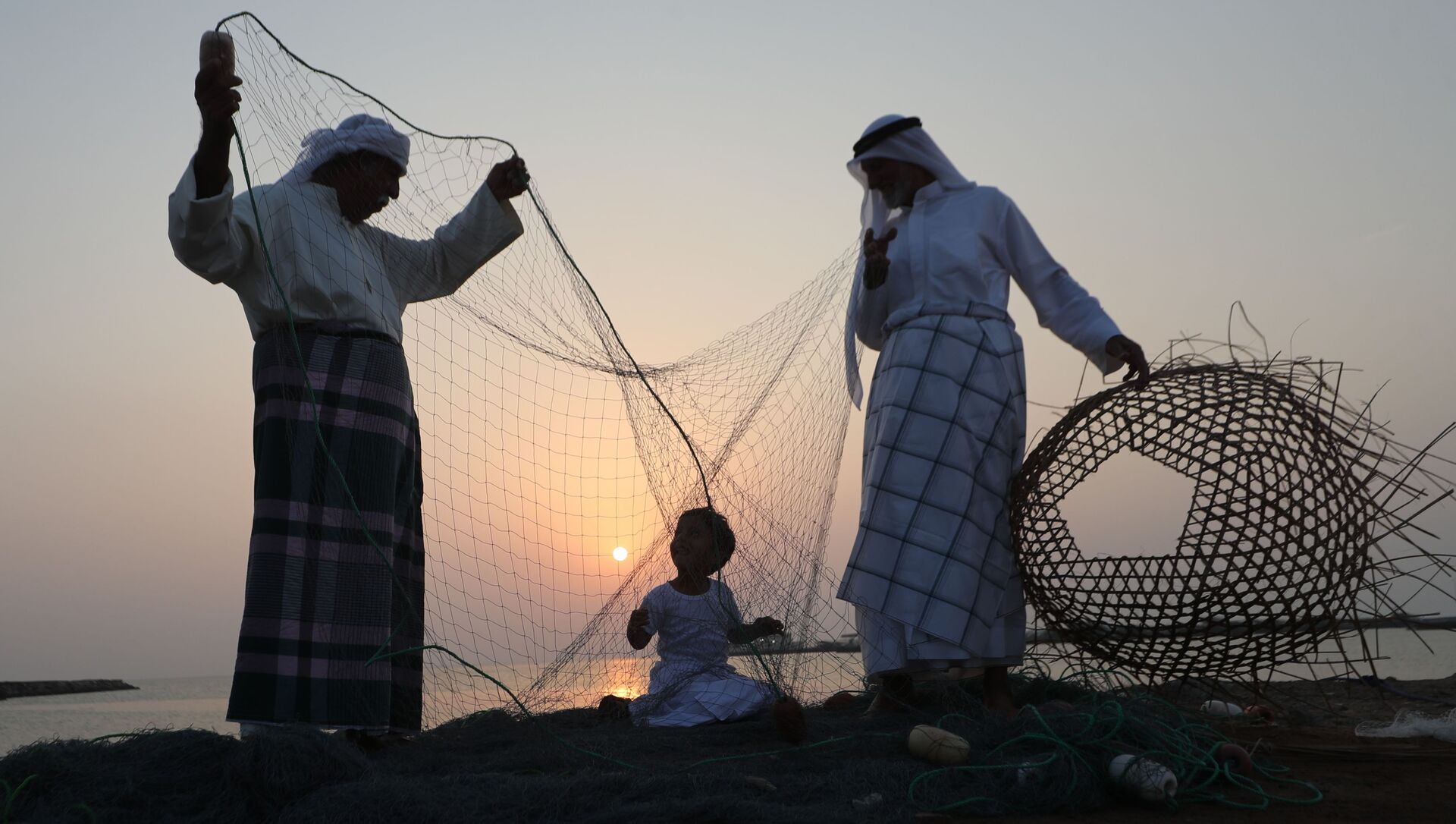 رجال إمارتيون يدربون طفلا على الحرف الصناعية اليدوية خلال مهرجان دلما البحري في الخريج العربي، 40 كم عن أبو ظبي، الإمارات المتحدة 27 أكتوبر/ تشرين الأول 2018 - سبوتنيك عربي, 1920, 13.07.2021