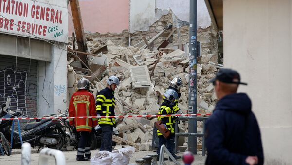 عمال الإنقاذ الفرنسيون يقفون بالقرب من الأنقاض بعد انهيار المباني في وسط مرسيليا، 6 نوفمبر/تشرين الثاني 2018 - سبوتنيك عربي