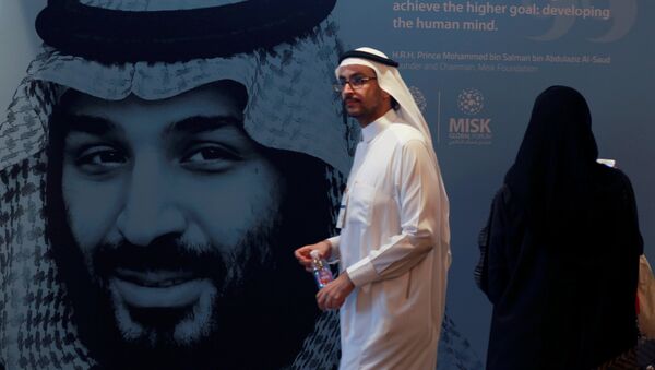 أحد المشاركين يسير بجوار صورة ولي العهد السعودي الأمير محمد بن سلمان خلال منتدى مسك العالمي في الرياض - سبوتنيك عربي
