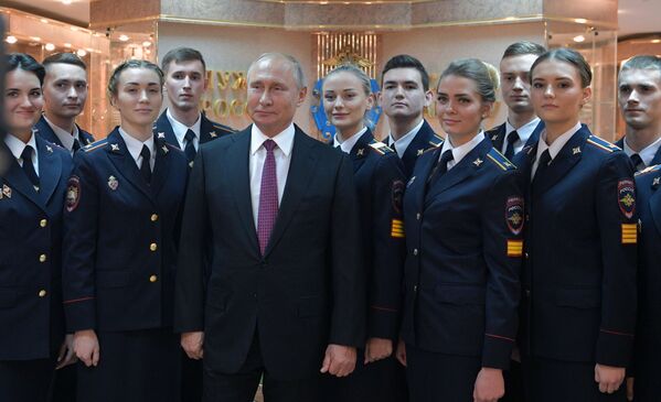 الرئيس فلاديمير بوتين خلال اتخاذ صورة جماعية مع تلامذة جامعة موسكو التابعة لزوارة الداخلية الروسيا (باسم ف. يا. كيكوتيا) - سبوتنيك عربي