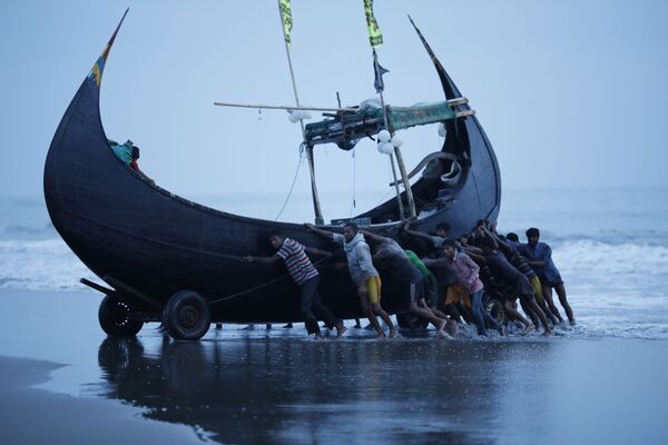 صيادون يدفعون بمركب الصيد إلى قرية الصيد شابلابور، بنغلادش 13 نوفمبر/ تشرين الثاني 2018 - سبوتنيك عربي