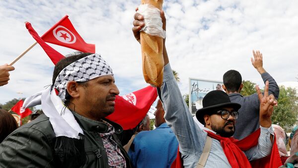 رجل يحمل الخبز أثناء احتجاج ضد رفض الحكومة رفع الأجور في تونس - سبوتنيك عربي