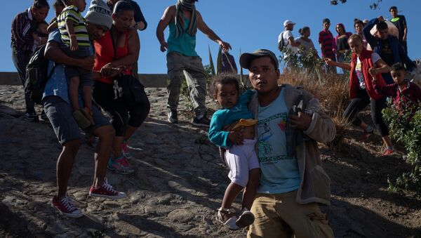 مهاجرين يحاولون اقتحام الحدود الأمريكية المكسيكية - سبوتنيك عربي