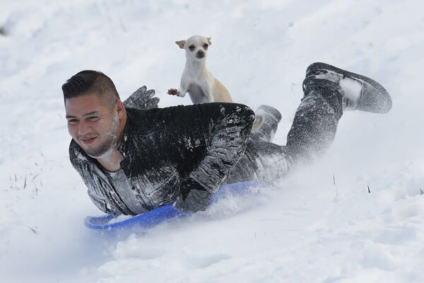 جوني ميندوزا وكلبه سوبي يتزحلق من تل جليدي في كانساس، كندا - سبوتنيك عربي