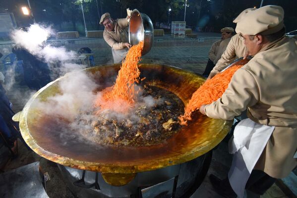 طهاة خلال اعداد أكبر طبق بيلاو (أو بيلاف) على طريقة دوشنبه ، خلال مهرجان أوشي بالاف في حديقة فردافسيفي دوشنبه، طاجكستان - سبوتنيك عربي