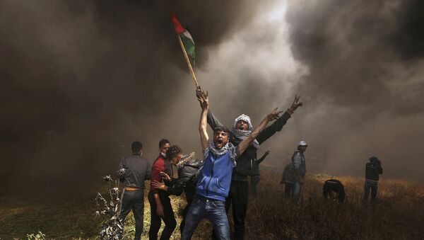 صورة العام لـ2018: متظاهرون فلسطينيون يصرخون خلال مواجهات مع القوات الإسرائيلية في مظاهرة مطالبين بحق العودة إلى وطنهم على الحدود بين إسرائيل وشرق مدينة غزة - سبوتنيك عربي