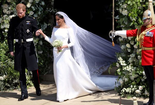 الأمير هاري ودوقة ساسيكس ميغان ماركل أثناء خروجهما من كنيسة القديس جورج في قلعة وندسور ، 19 مايو/ أيار 2018 - سبوتنيك عربي