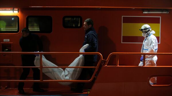 جثة مهاجرة في أثناء نقلها من قارب إنقاذ في ميناء ملقة - سبوتنيك عربي