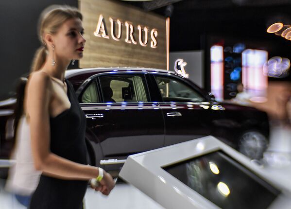 فتاة تقف أمام سيارة Aurus Senat في المعرض الدولي للسيارات لعام 2018 - سبوتنيك عربي
