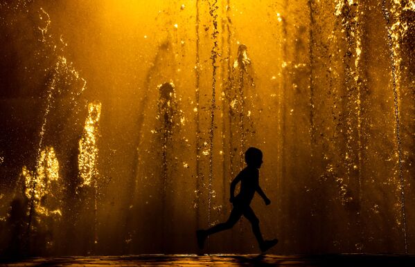 أطفال يلعبون بين نافورات المياه في يوم حار في فولغوغراد، روسيا - سبوتنيك عربي