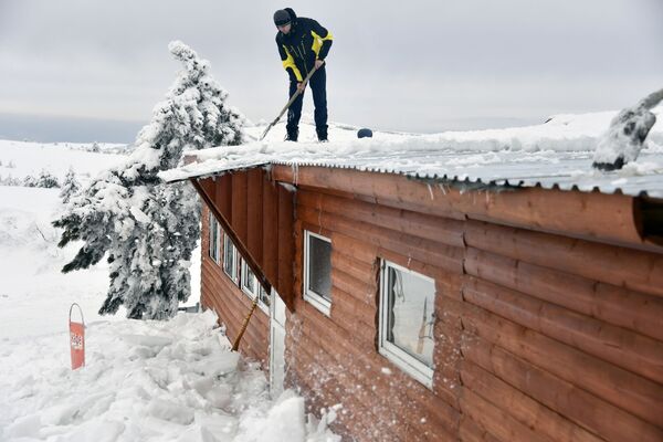 تنظيف سقف منزل من الثلوج على هضبة آي بيتري في شبه جزيرة القرم الروسية - سبوتنيك عربي