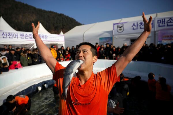أحد المشاركين في مهرجان صيد السمك على الجليد في هواتشيون، الصين 5 يناير/ كانون الثاني 2019 - سبوتنيك عربي