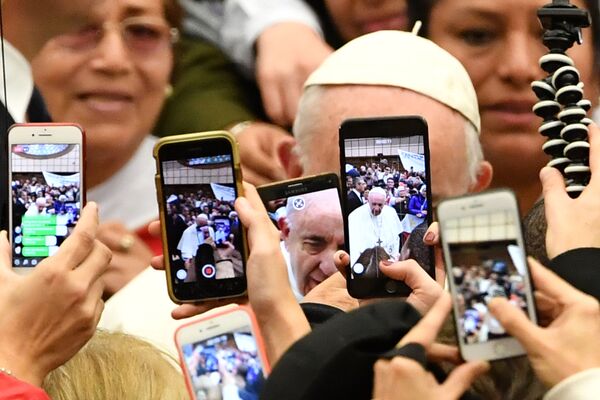 المصلون يلتقطون صورا ويسجلون فيديو لبابا الفاتيكان فرانسيس لدى وصوله إلى اللقاء الأسبوعي العام في قاعة بولس السادس في الفاتيكان، 9 يناير/ كانون الثاني 2019 - سبوتنيك عربي