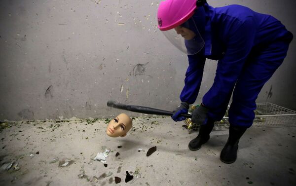 غرفة الغضب في بكين - فتاة ترتدي زيا واقيا وتقوم بتحطيم رأس تمثال، الصين 12 يناير/ كانون الثاني 2019 - سبوتنيك عربي