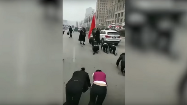 عقاب خاص للموظفين زحفا على الأرض  في الصين - سبوتنيك عربي
