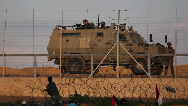متظاهرون فلسطينيون في مواجهة القوات الإسرائيلية خلال احتجاج على السياج الحدودي بين إسرائيل وقطاع غزة - سبوتنيك عربي