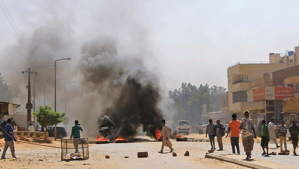 متظاهرون سودانيون يحرقون إطارات بالقرب من منزل أحد المتظاهرين الذي توفي جراء إصابته بعيار ناري خلال مظاهرات مناهضة للحكومة في الخرطوم - سبوتنيك عربي