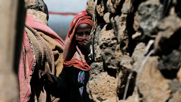 امرأة تقف بالقرب من كوخها في مخيم مؤقت للنازحين قرب صنعاء - سبوتنيك عربي