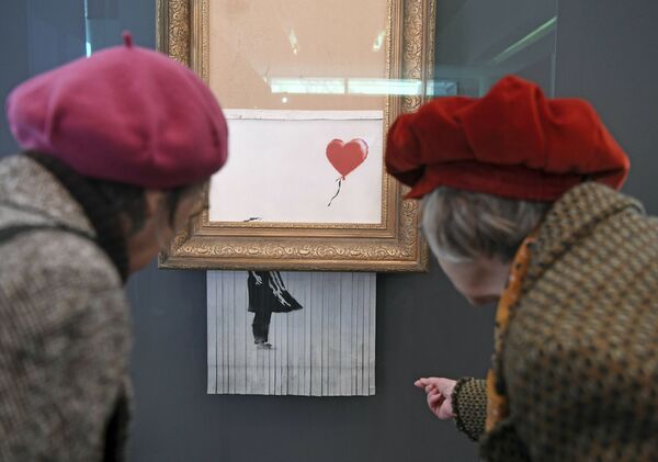 ينظر الناس إلى لوحة بانكسي الممزقة الحب في الباحة (Love is in the Bin) في متحف فريدر بوردا في بادن-بادن يوم الثلاثاء الماضي 5 فبراير/ شباط 2019، حيث سيعرض العمل من 5 فبراير/ شباط إلى 3 مارس/ آذار 2019. واسم اللوحة من الأساس فتاة والبالون (A Girl With Balloon)، ومنذ أن دمرت االوحة بنفسها في مزاد فني في لندن، أطلقت عليها اسم Love is in the Bin. - سبوتنيك عربي