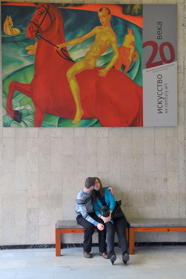 شخصان على خلفية لافتة إعلان لعرض فني بمتحف تريتياكوفسكايا في موسكو - سبوتنيك عربي