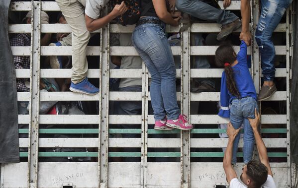 مهاجرون فنزويليون يصعدون على شاحنة على الطريق من كوكوتا إلى بامبلونا، في دائرة نورتي دي سانتاندر، كولومبيا، في 10 فبراير/ شباط 2019 - سبوتنيك عربي