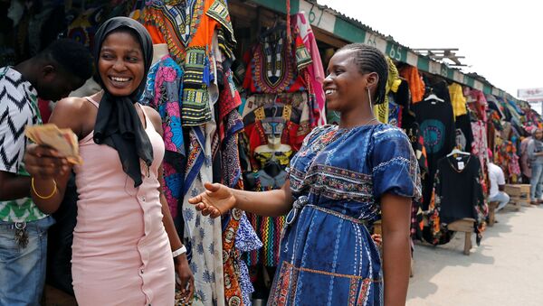 بائعات الملابس يتبادلن المال في مارينا، في العاصمة التجارية في نيجيريا لاغوس، نيجيريا في 11 فبراير/ شباط 2019 - سبوتنيك عربي