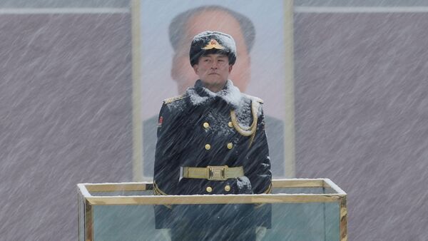 أحد أفراد الحرس العسكري يقف أمام صورة الرئيس الصيني الراحل ماو تسي تونغ أثناء تساقط الثلوج في ميدان تيانانمين في بكين بالصين في 12 فبراير/ شباط 2019 - سبوتنيك عربي