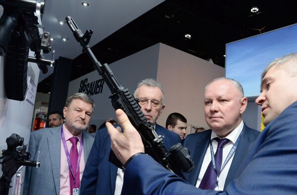 المدير العام لشركة روس أوبورونن إكسبورت، الكسندر ميخييف (يسار) يتفقد بندقية كلاشنيكوف -200  ، والتي صنعتها شركة كلاشنيكوف، في معرض آيدكس 2019 - سبوتنيك عربي