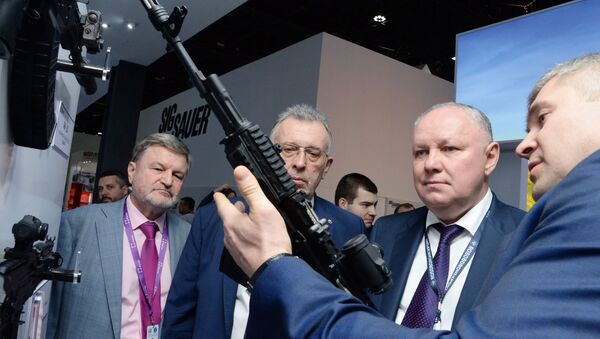 المدير العام لشركة روس أوبورونن إكسبورت، الكسندر ميخييف (يسار) يتفقد بندقية كلاشنيكوف -200  ، والتي صنعتها شركة كلاشنيكوف، في معرض آيدكس 2019 - سبوتنيك عربي