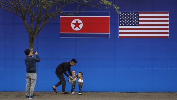 مواطنون يلتقطون صورة على خلفية علمي كوريا الشمالية والولايات المتحدة الأمريكية، في ظل القمة الأمريكية الكورية في هانوي، فيتنام 27 فبراير/ شباط 2019 - سبوتنيك عربي