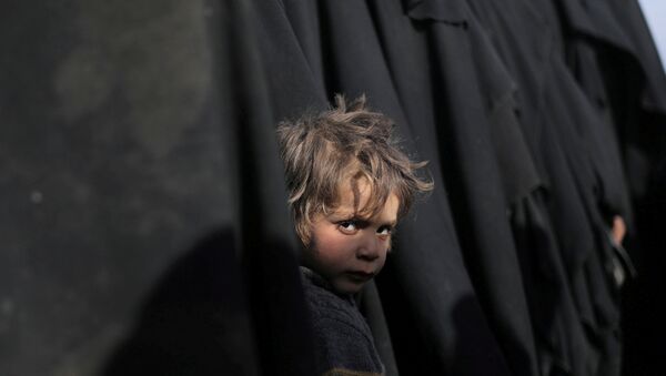 صبي ينظر إلى الكاميرا بالقرب من الباغوز محافظة دير الزور في سوريا - سبوتنيك عربي