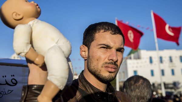 متظاهر في تونس يحمل دمية لطفل للتنديد بوفاة أطفال رضع في مستشفى حكومي - سبوتنيك عربي