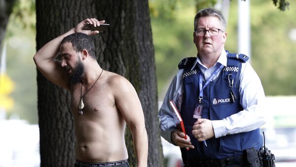 رجل وشرطي في مكان الهجوم الإرهابي على مسجد النور في نيوزيلاندا - سبوتنيك عربي