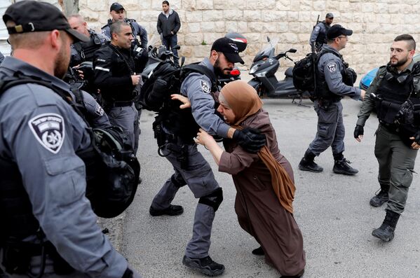 امرأة فلسطينية تحاول اختراق حاجز الشرطة الإسرائيلية بعد أن أغلقت السلطات الإسرائيلية المداخل إلى مسجد الأقصى في القدس، 12 مارس/ آذار 2019 - سبوتنيك عربي