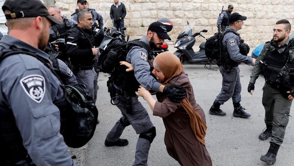 امرأة فلسطينية تحاول اختراق حاجز الشرطة الإسرائيلية بعد أن أغلقت السلطات الإسرائيلية المداخل إلى مسجد الأقصى في القدس، 12 مارس/ آذار 2019 - سبوتنيك عربي