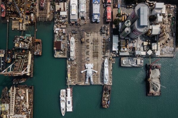 منحوتة KAWS:HOLIDAY:  للفنان والمصمم الأمريكي برايان دونيلي في حوض بناء السفن في هونغ كونغ، 11 مارس/ آذار 2019 - سبوتنيك عربي