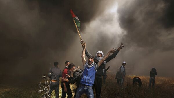 متظاهرون فلسطينيون يصرخون خلال اشتباكات مع القوات الإسرائيلية في احتجاج على الحدود بين إسرائيل وغزة شرق مدينة غزة - سبوتنيك عربي
