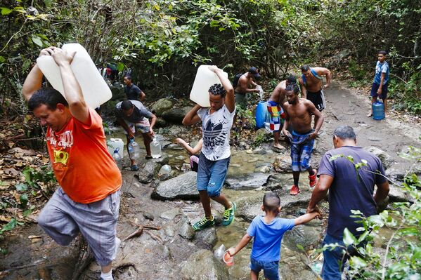 أشخاص يملأون العبوات والزجاجات بالمياه القادمة من جبل أفيلا إلى كراكاس - سبوتنيك عربي