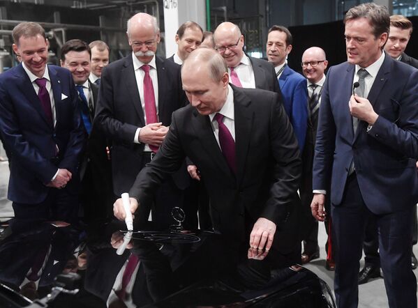 الرئيس فلاديمير بوتين يوقع على سيارة مرسيدس-بينز خلال مراسم افتتاح مصنع مرسيدس لتصنيع السيارات الألمانية في منقطة موسكو - سبوتنيك عربي