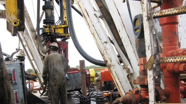 عمال شركة النفط والغاز الأمريكية أباتشي كورب يقومون بحفر آبار أفقية في وولف كامب شيل في حوض بيرميان غرب تكساس بالقرب من بلدة ميرتزون - سبوتنيك عربي