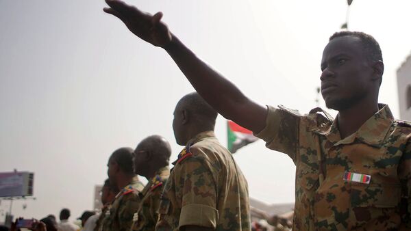 جنود في السودان بالقرب من متظاهرين أثناء مظاهرة تطالب بتنحي عمر البشير - سبوتنيك عربي