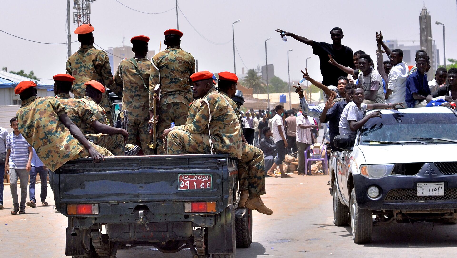مظاهرات سودانية تحتفل وهي تسير باتجاه مركبة عسكرية بالقرب من وزارة الدفاع في الخرطوم - سبوتنيك عربي, 1920, 25.10.2021