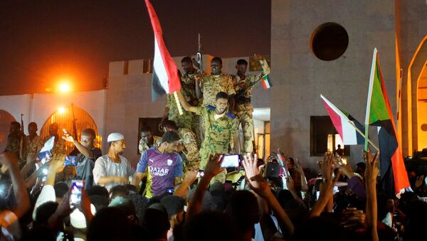 الجيش السوداني ينضم إلى المتظاهرين للاحتفال بعد تنحي وزير الدفاع عوض بن عوف كرئيس للمجلس العسكري الانتقالي الحاكم في البلاد - سبوتنيك عربي