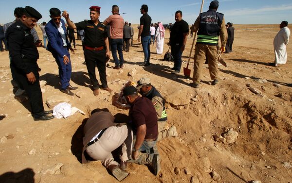 عراقيون من الدفاع المدني وأكراد يفحصون مقبرة جماعية اكتشفت للأكراد في غرب مدينة السماوة - سبوتنيك عربي