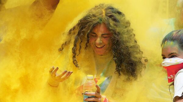 متطوعون يصبون مسحوقا من اللون الأصفر على المتسابقين الذين اجتازوا خط نهاية السباق، في أول مسابقة الألوان في الجيزة، مصر في 13 أبريل/ نيسان 2019 - سبوتنيك عربي