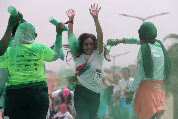 قام متطوعون بصب مسحوق أخضر على الحائز على المركز الثاني في أول مسابقة الألوان في الجيزة، مصر في 13 أبريل/ نيسان 2019 - سبوتنيك عربي