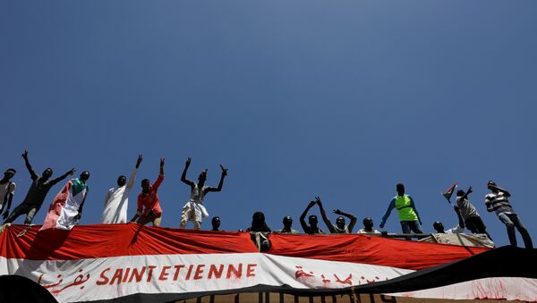 متظاهرون سودانيون يحتجون وهم يقفون على جسر للسكك الحديدية بالقرب من وزارة الدفاع في الخرطوم - سبوتنيك عربي