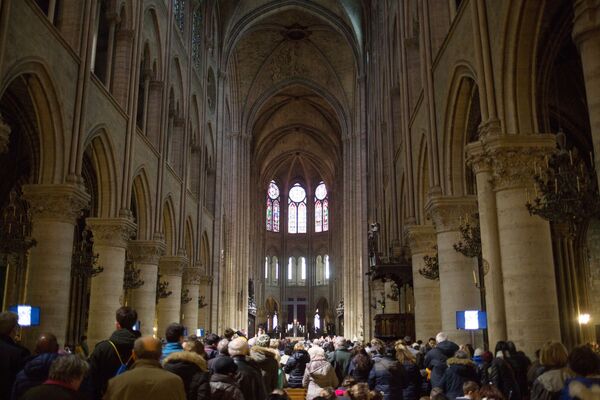 مصلون أثناء خدمة يوم الجمعة العظيمة، قبل عيد الفصح الكاثوليكي في كاتدرائية نوتردام - سبوتنيك عربي