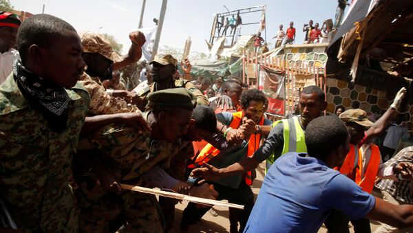 متظاهرون سودانيون يضربون رجلا يعتقد أنه عميل حكومي بينما يحاول الجنود إخراجه من الحشد في الخرطوم - سبوتنيك عربي