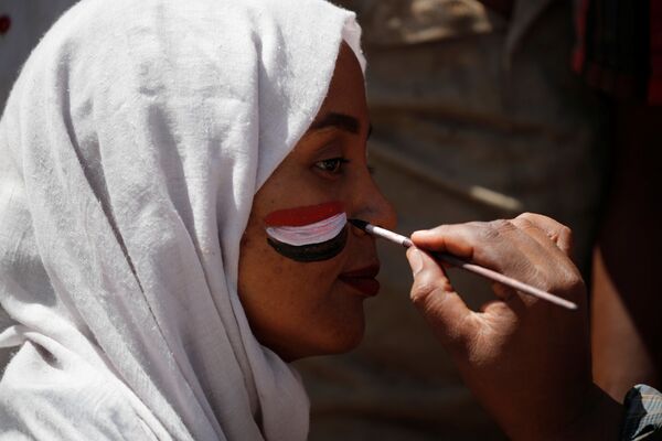 رجل يرسم العلم السوداني على وجه المتظاهرين في الخرطوم رجل يرسم العلم السوداني على وجه المتظاهرين في الخرطوم - سبوتنيك عربي